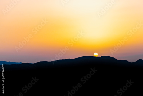 Wallpaper Mural The hot sun hides behind the mountains on a summer day at dusk. Torontodigital.ca