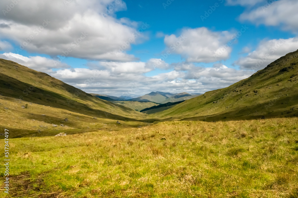 Beautiful mountainous landscape of the Trossachs National Park in Scotland in the summer with hills, valleys, river streams, reservoirs and mountain peaks Beautiful mountainous landscape of the Trossachs National Park in Scotland in the summer with hills, valleys, river streams, reservoirs and mountain peaks