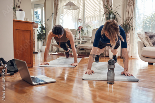 Pretty women working out at home. Adult ladies with beautiful shaped bodies exercising in the apartment.