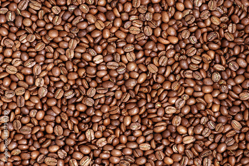 Roasted coffee beans texture for background. Organic natural roast grain background with copy space for text, top view. Close up grains flat lay. Healthy food macro concept.