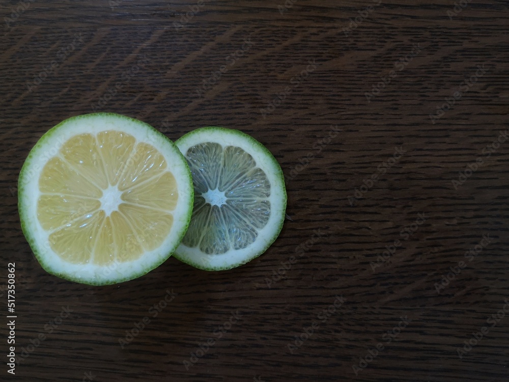 lemon and lime sliced on wooden dark background lemon and lime sliced on wooden dark background