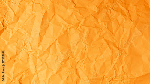 The orange paper background is wrinkled, creating a rough texture with light and shadow.