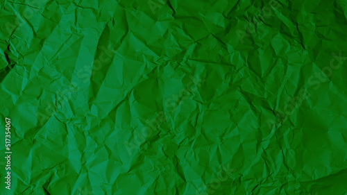 The green paper background is wrinkled  creating a rough texture with light and shadow.