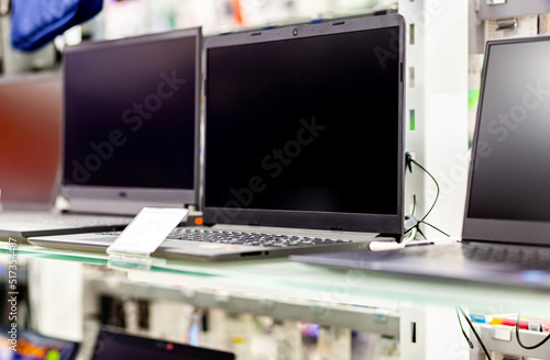A sample of laptops in a shop window behind glass on a blurred background