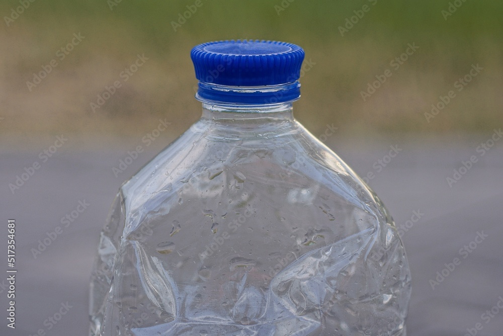 part of one plastic wet bottle closed with a blue cork in the street part of one plastic wet bottle closed with a blue cork in the street
