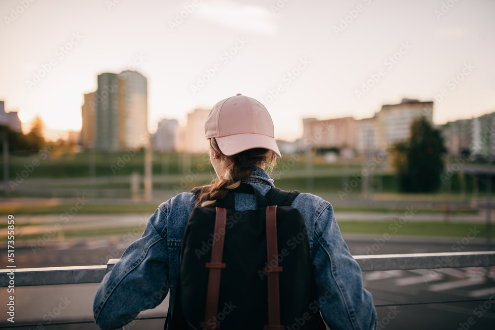 Tourist admires the overview of the sights of the city. Woman with backpack enjoy beautiful city view, traveler mock up top of the city. Tourist admires the overview of the sights of the city. Woman with backpack enjoy beautiful city view, traveler mock up top of the city.