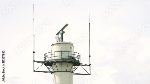 Marine radar rotating on a white tower.