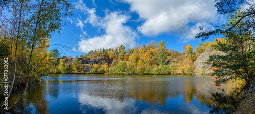 Fototapeta Naklejka Na Ścianę i Meble -  flooded quarry surrounded by trees in autumn
