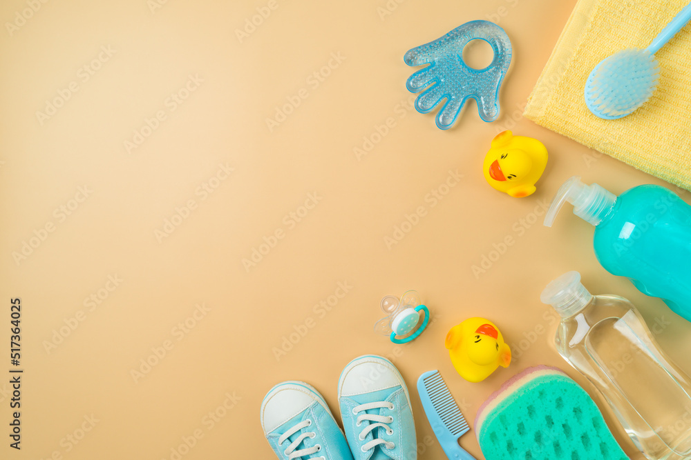 Baby bath and children health care products on beige background. Infant shampoo, duck toys and towel flat lay composition. Top view Baby bath and children health care products on beige background. Infant shampoo, duck toys and towel flat lay composition. Top view