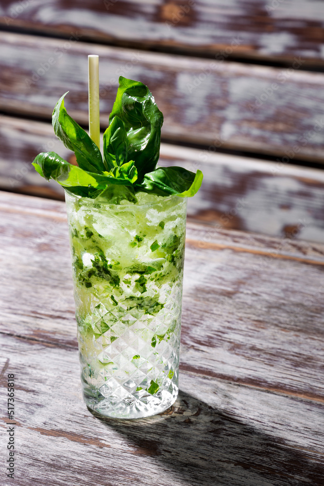 Cocktail with basil, ice and a straw Cocktail with basil, ice and a straw