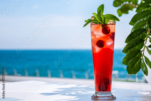 A cocktail with ice, cherries and mint