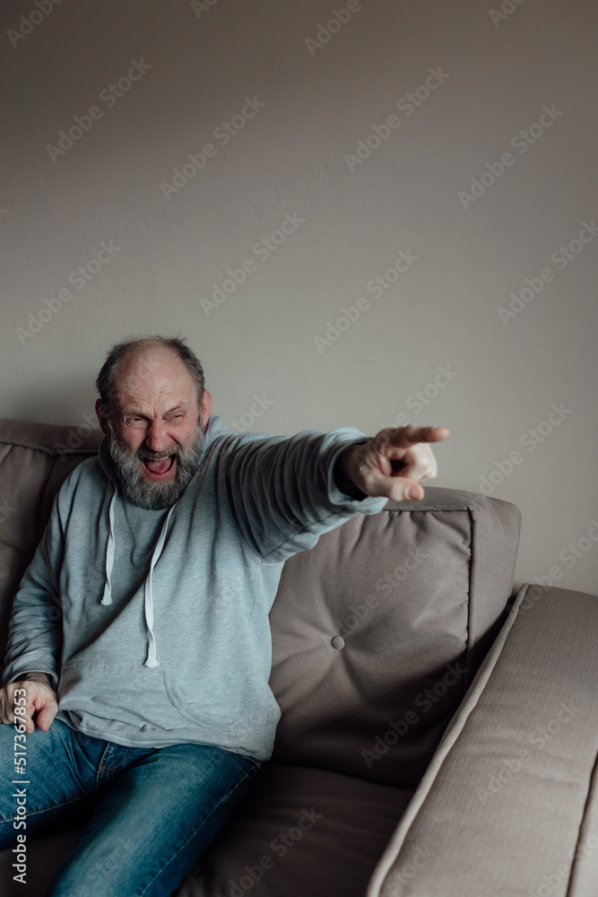 Ukrainian worried middle aged man was frightened by the loud sound and closed his ears in fear. Unhappy mature older grandfather at home. Ukrainian worried middle aged man was frightened by the loud sound and closed his ears in fear. Unhappy mature older grandfather at home.