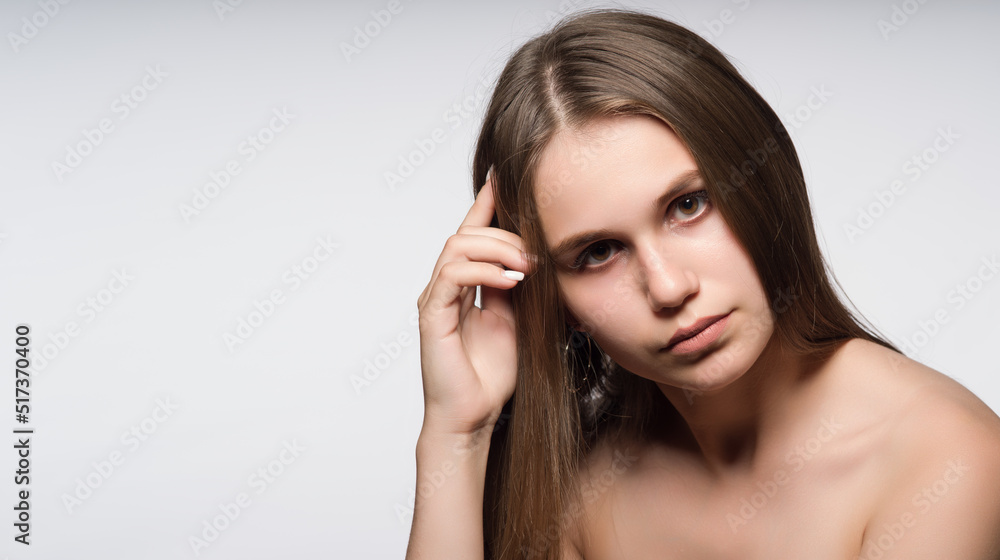 A young, attractive girl with beautiful, long, straight hair, brown eyes and bare shoulders. Close-up portrait. Free space for text advertising A young, attractive girl with beautiful, long, straight hair, brown eyes and bare shoulders. Close-up portrait. Free space for text advertising