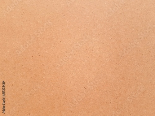 Orange color paper texture and grain for aesthetic of autumn and fall design. Color and light on warm earth tone paper background.