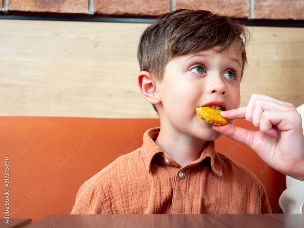 Little toddler boy eating nuggets indoor Little toddler boy eating nuggets indoor