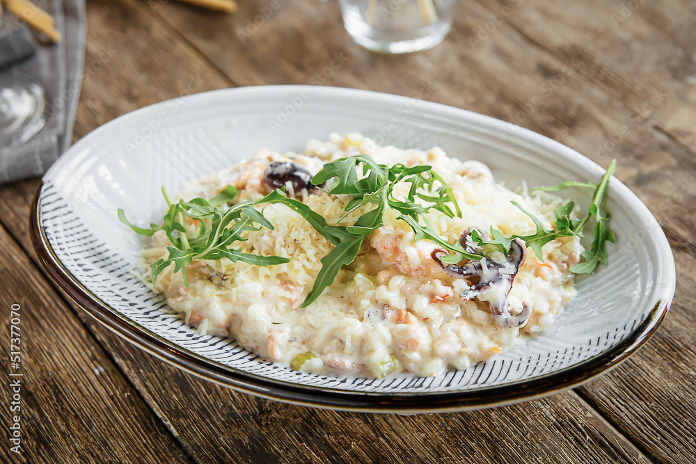 Portion of gourmet seafood risotto on wooden background Portion of gourmet seafood risotto on wooden background
