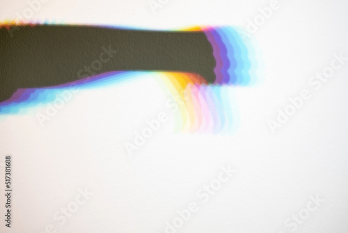 Foto Rainbow shadow of a hand with thumb down, on a white background