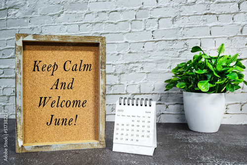 Motivational and inspirational quote on wooden frame with June 2022 calendar.
