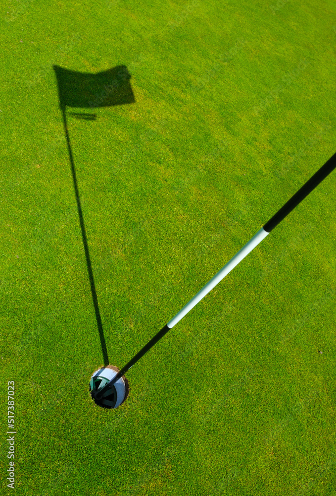 Obraz premium Golf Course Hole With Flagstick Shadow