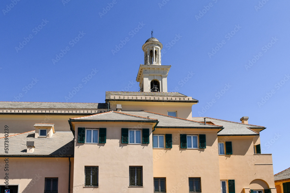 Low-angle view of the side of the Church of Saint Anthony with the bell tower against clear blue sky in the old fishing village, Boccadasse, Genoa, Liguria, Italy