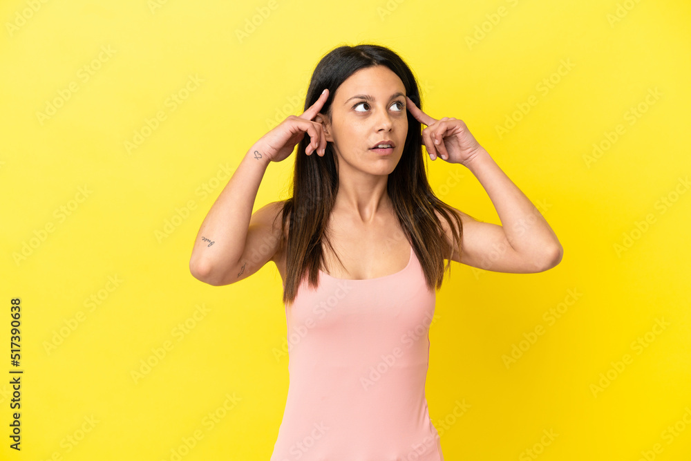 Young caucasian woman isolated on yellow background having doubts and thinking Young caucasian woman isolated on yellow background having doubts and thinking