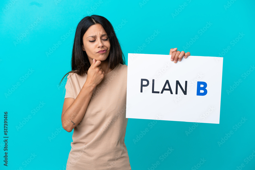 Young woman over isolated background holding a placard with the message PLAN B and thinking Young woman over isolated background holding a placard with the message PLAN B and thinking