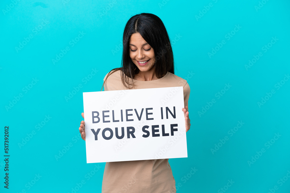 Young woman over isolated background holding a placard with text Believe In Your Self Young woman over isolated background holding a placard with text Believe In Your Self