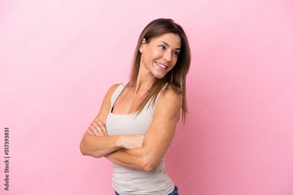 Middle age caucasian woman isolated on pink background with arms crossed and happy Middle age caucasian woman isolated on pink background with arms crossed and happy
