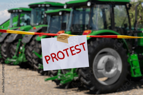 The inscription PROTEST on the background of tractors. Farmers protest symbol.