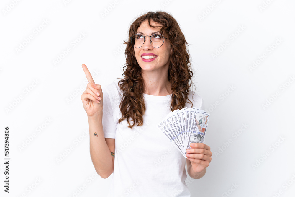 Obraz premium Young woman with curly hair taking a lot of money isolated background on white background pointing up a great idea