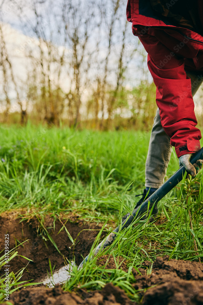 Farming, gardening, farming and people concept - unrecognizable young woman with a shovel digs the ground in a farm on a sunny day. Farming, gardening, farming and people concept - unrecognizable young woman with a shovel digs the ground in a farm on a sunny day.