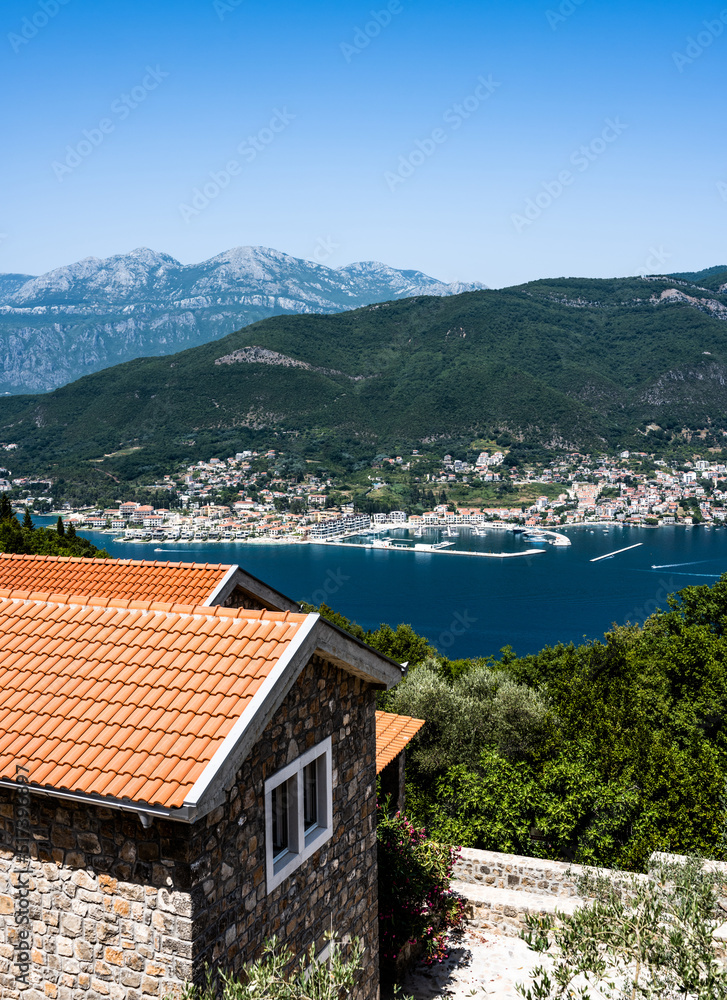 Kotor town and bay view from above in Montenegro with red roofs houses in the foreground. Scenic panorama on Adriatic sea and mountains