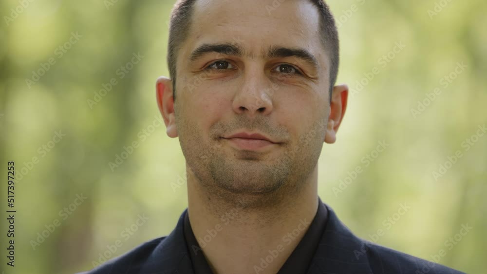Close up portrait male face caucasian hispanic businessman entrepreneur adult man serious confident handsome smart guy successful gentleman wears black formal suit looking at camera stand in city park Close up portrait male face caucasian hispanic businessman entrepreneur adult man serious confident handsome smart guy successful gentleman wears black formal suit looking at camera stand in city park