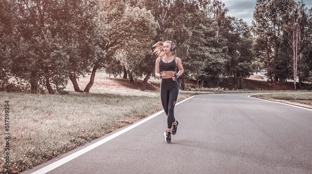 Fototapeta premium Sports girl jogging in the park. The concept of a healthy lifestyle. Sports Equipment. Fitness style advertisement.