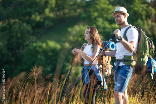 A happy couple climbs the hills in hiking gear.