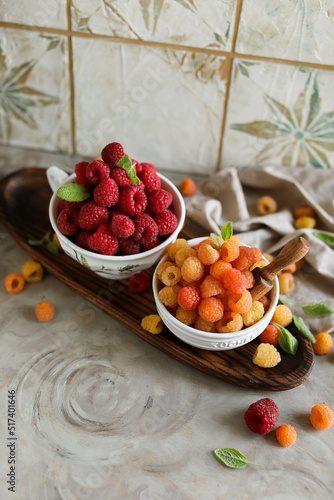 Ripe juicy raspberries in a small bowl. Summer harvest of delicious berries.