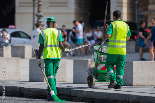Des agents d'entretien du service public ramassant des déchets dans la ville avec des balais et des sacs poubelles afin d'avoir un environnement propre. Concept écologique. 