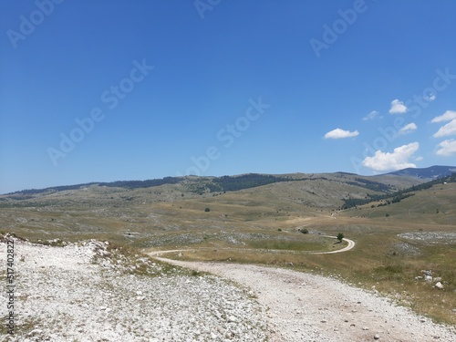 Landscape with gravel road, forest and clouds on mountain Bjelasnica, Bosnia and Herzegovina