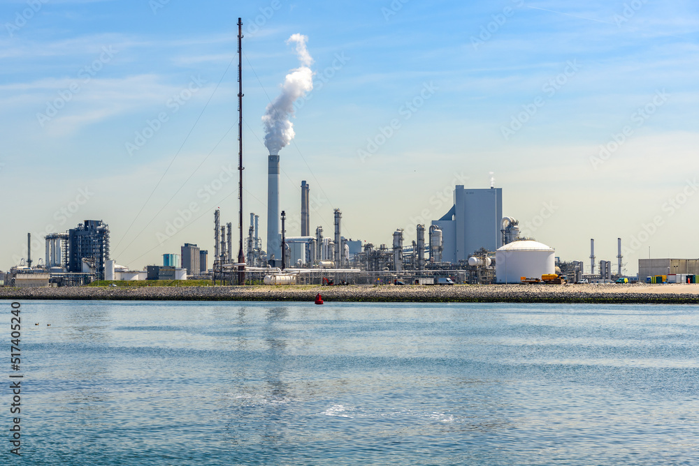 View of an oil refinery on a sunny summer day. Port of Rotterdam, Netherlands. View of an oil refinery on a sunny summer day. Port of Rotterdam, Netherlands.