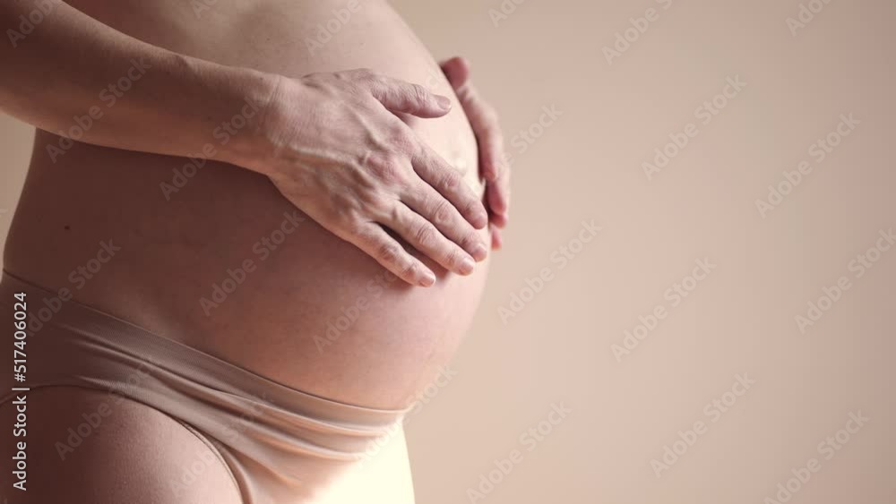 pregnant woman. health pregnancy motherhood procreation concept. close-up belly of a sunlight pregnant woman. woman waiting for a newborn baby. pregnant woman holding her belly indoors pregnant woman. health pregnancy motherhood procreation concept. close-up belly of a sunlight pregnant woman. woman waiting for a newborn baby. pregnant woman holding her belly indoors