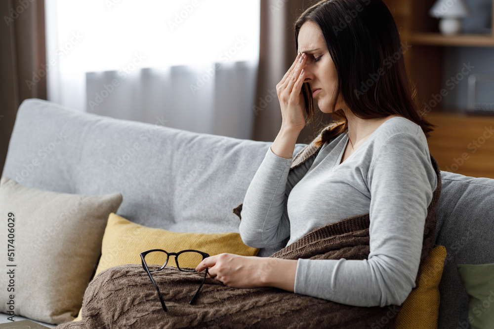 Young woman woman taking off eyeglasses feeling eye strain.Tired woman with closed eyes massaging eyes having painful sensations.Migraine, head ache, bad vision, chronic fatigue and eyestrain concept Young woman woman taking off eyeglasses feeling eye strain.Tired woman with closed eyes massaging eyes having painful sensations.Migraine, head ache, bad vision, chronic fatigue and eyestrain concept