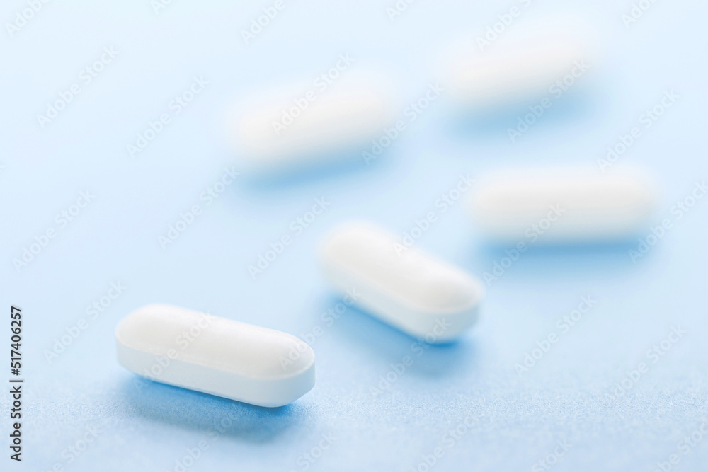 White pills on blue background