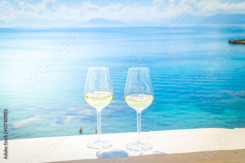 Two glasses of white wine with Corfu in background