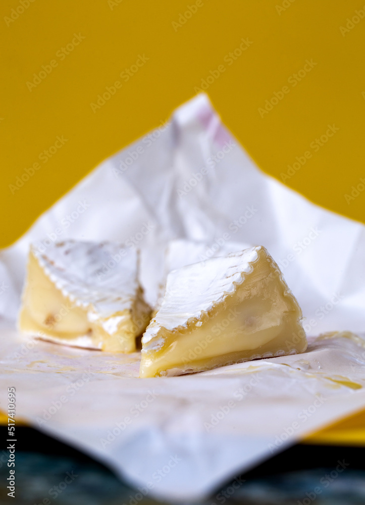 slices of sliced camembert cheese on yellow background