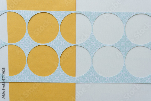 stencil with big circle cutouts on blank yellow and white paper