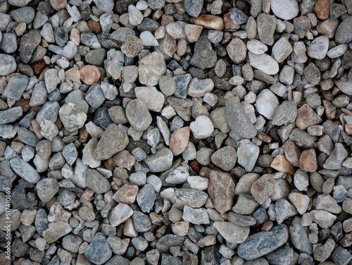 Small Stones in Shades of Blue-Gray and White in the Garden with a Bit of Trash on Top of Them