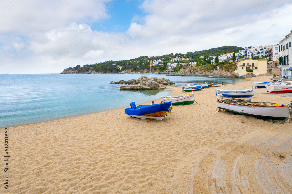 Fishing boats docked and moored on the sandy beach of the Spanish village of Calella de Palafrugell, Spain, on the Costa Brava coast.