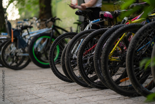 row of bicycles parked in the street for rent, eco friendly transport