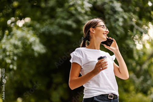 A girl in a park with a phone.