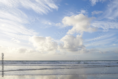 Copy space at the sea with a cloudy blue sky above the horizon. Calm ocean waters washing onto beach shore. Coastal landscape for a relaxing summer getaway in Torrey Pines, San Diego in California